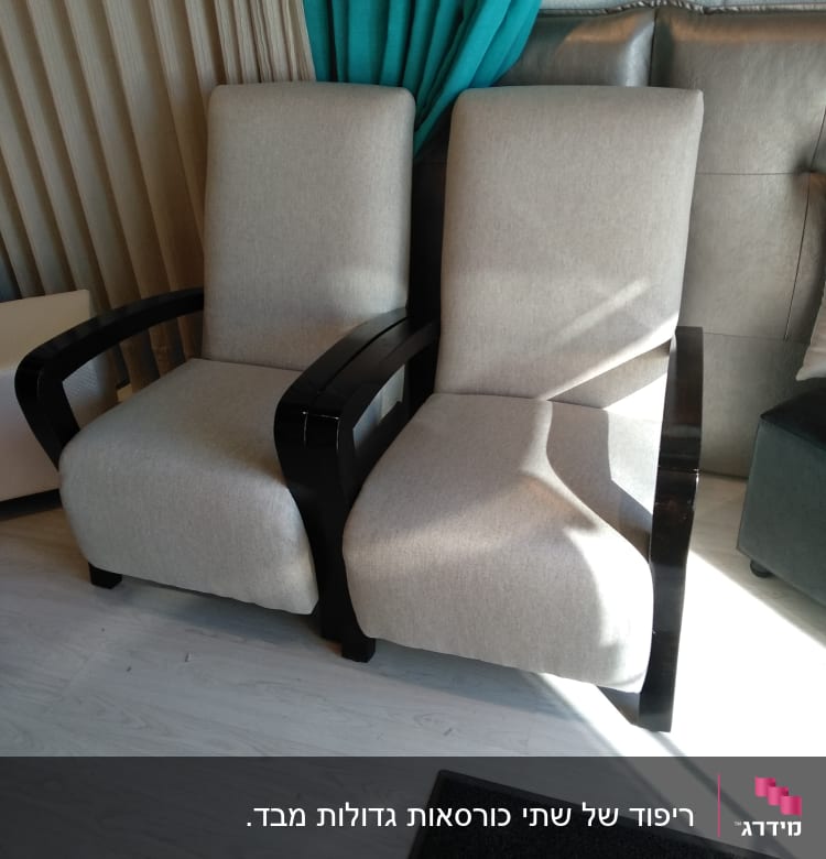 שני כורסאות מרופדות בבד בהיר עם ידיות עץ כהות